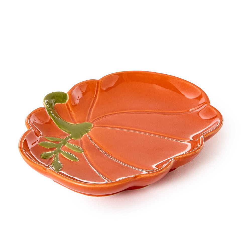 A side photo of a orange ceramic pumpkin-shaped plate with a green stem on a white background.