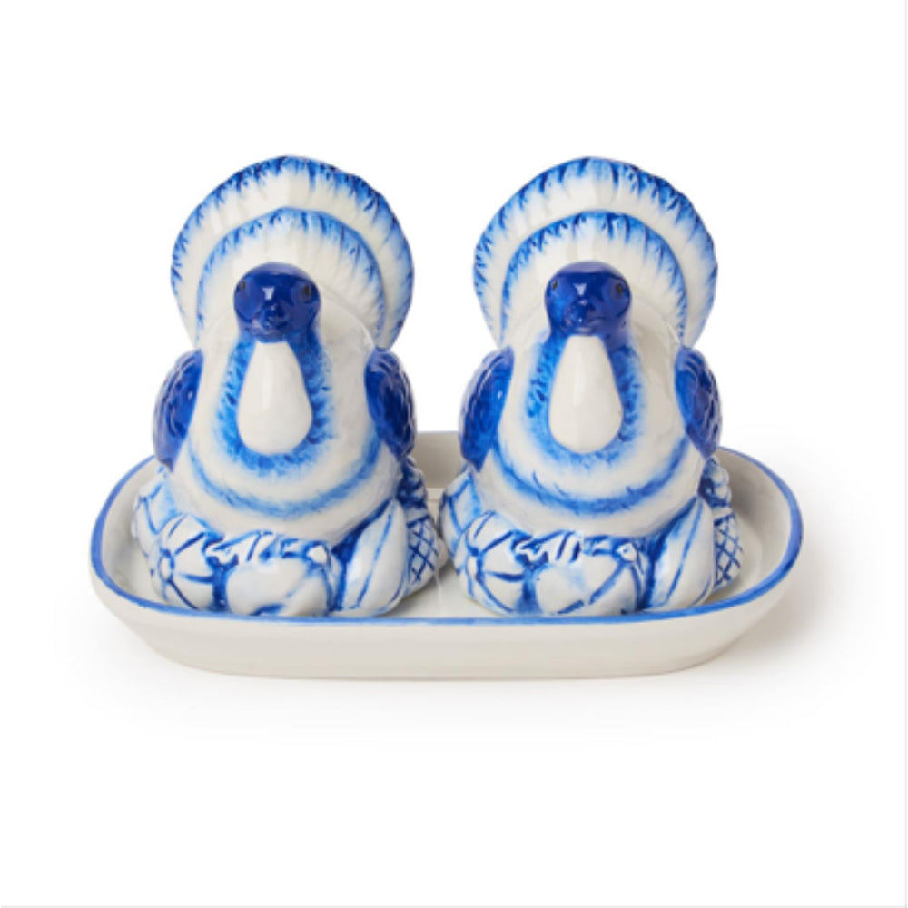 A pair of blue and white ceramic bird-shaped salt and pepper shakers sitting on a matching white and blue ceramic tray, photographed against a solid white background.