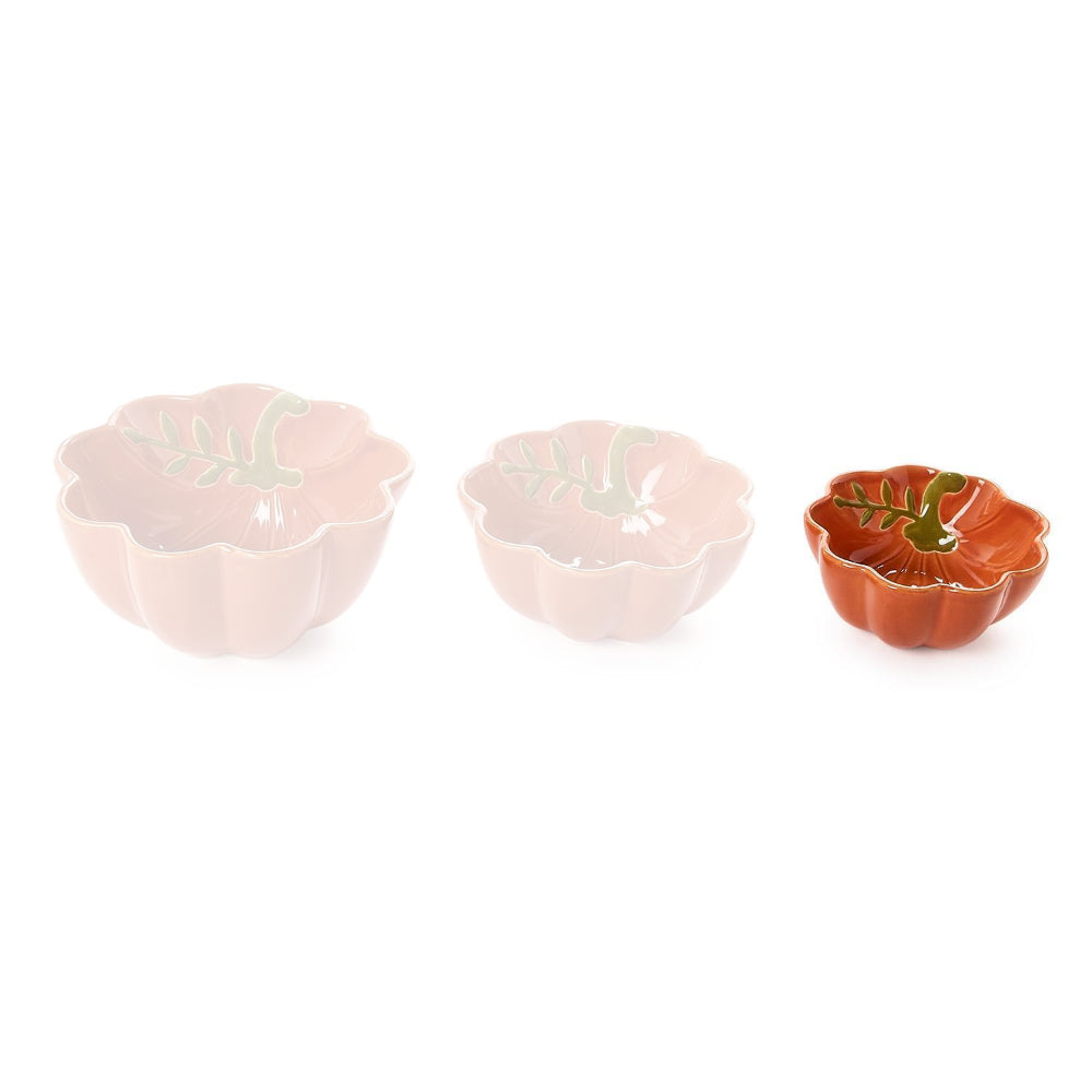 Small pumpkin-shaped ceramic bowl with scalloped edge and in a terracotta orange color with green leaf design inside and gold trim on a white backround.