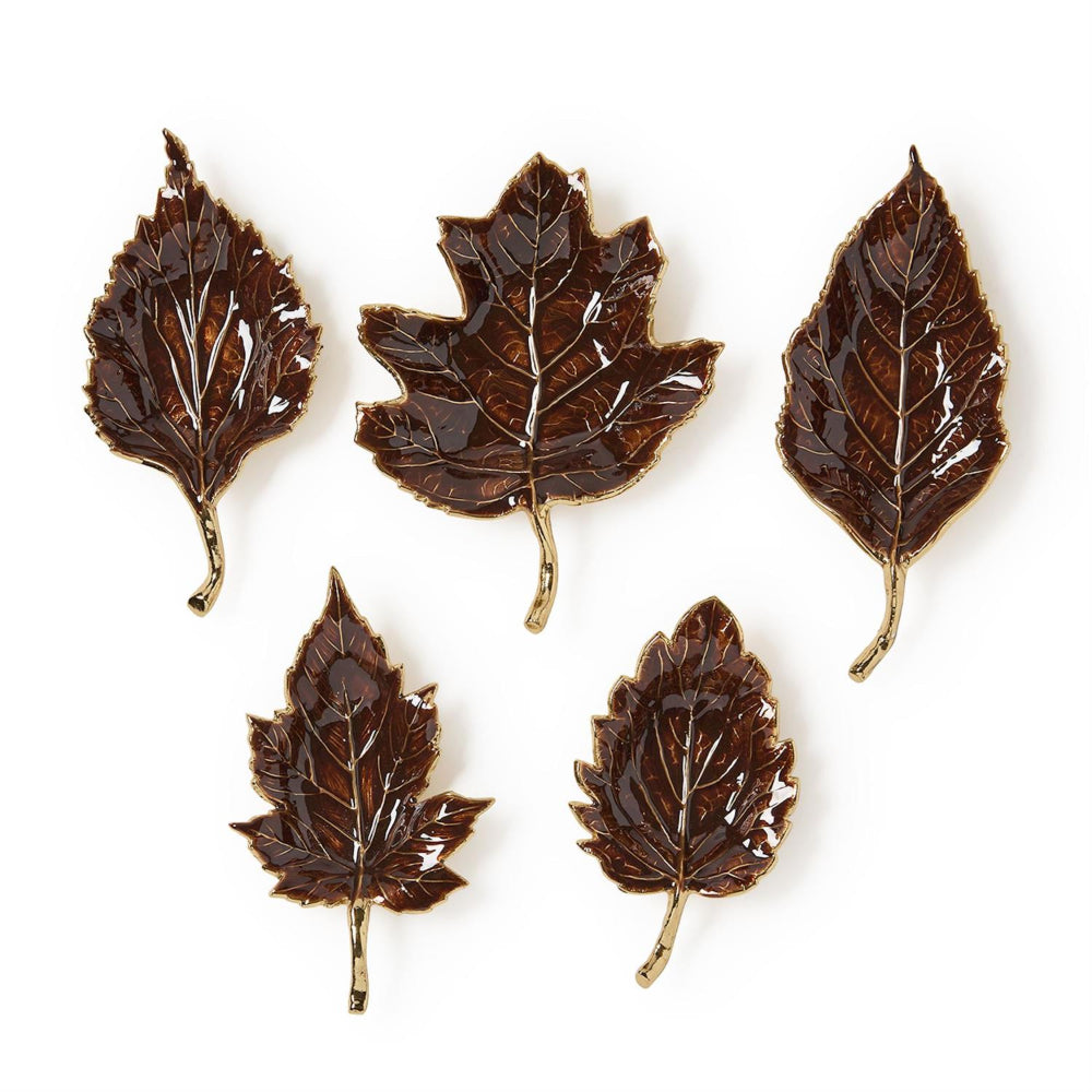 Five brown leaf-shaped coasters on a white background