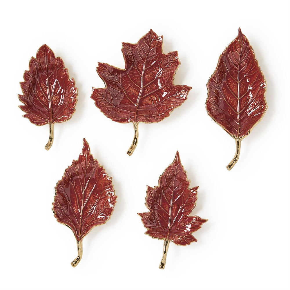 Five glossy red-brown leaf-shaped accessories with gold-tone stems, arranged on a plain white background.