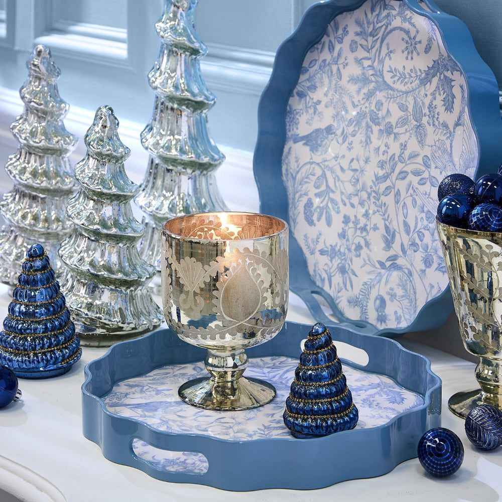 Decorative setting with blue and silver Christmas trees on a blue tray.