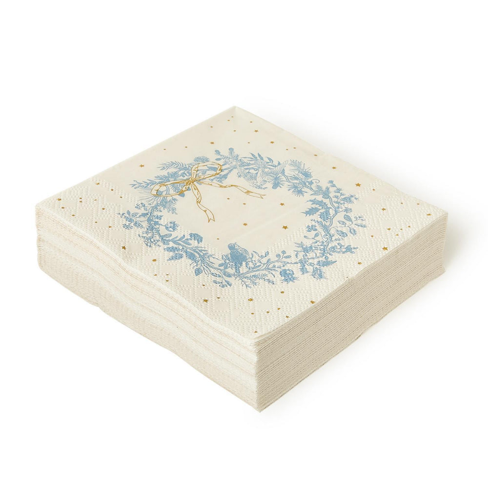 Decorative white christmas cocktail paper napkin with a blue wreath and gold bow on a white background.