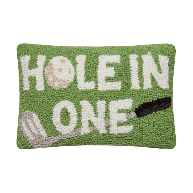 Decorative pillow with 'Hole in One' text and golf ball design on a green background
