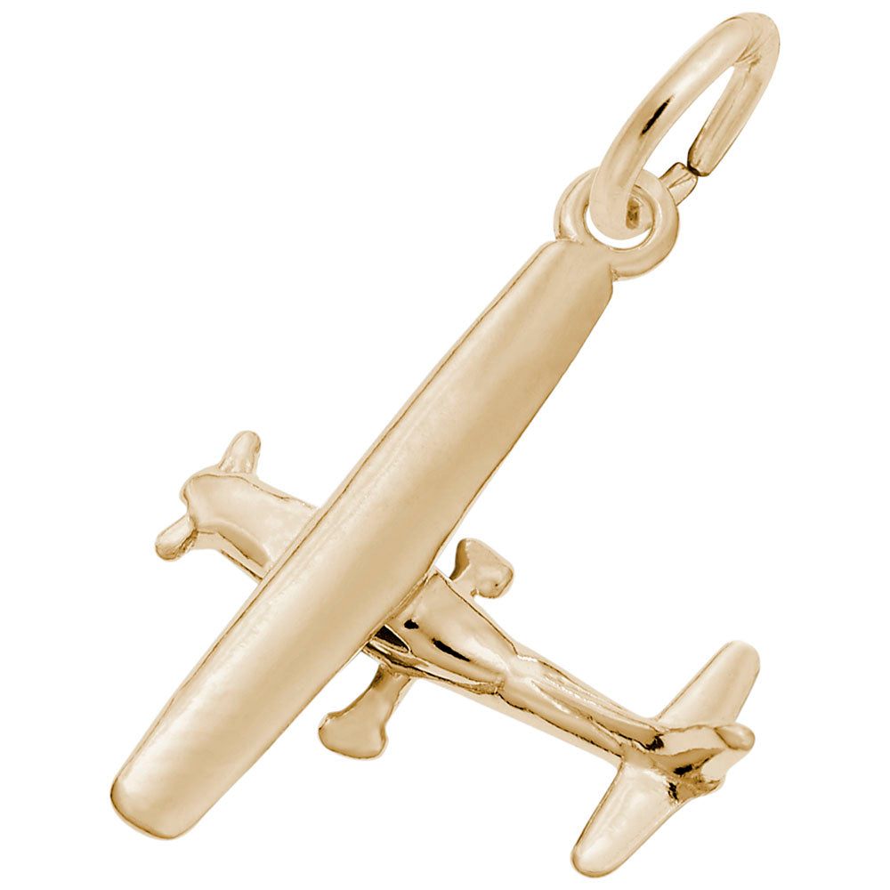 Gold airplane charm on a white background