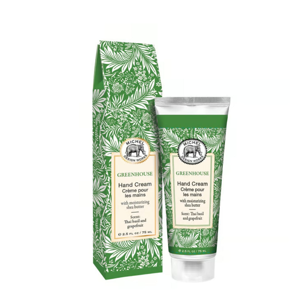 A squeeze tube of Greenhouse Hand Cream stands next to its matching paper packaging box on a plain white background. Both the tube and box feature a green and white tropical leaf pattern with a cream-colored label in the center.