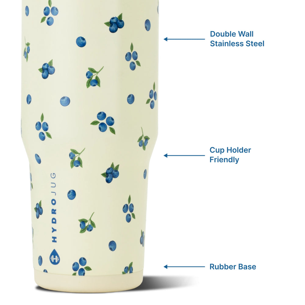 A HydroJug stainless steel tumbler with a cream background and a blue berry pattern, shown with callout arrows and text highlighting its features: 'Double Wall Stainless Steel,' 'Cup Holder Friendly,' and 'Rubber Base.'.