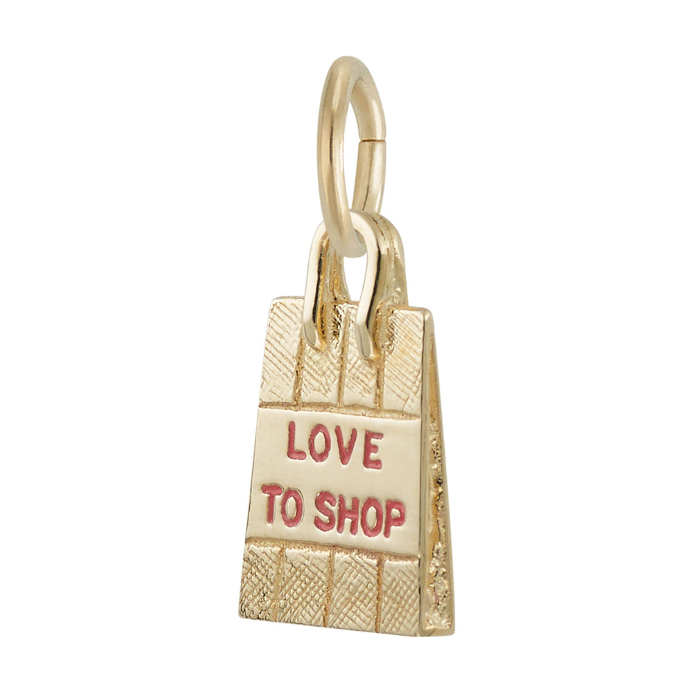 Angled view of a gold charm shaped like a shopping bag with the words 'LOVE TO SHOP' in pink enamel, shown on a plain white background.