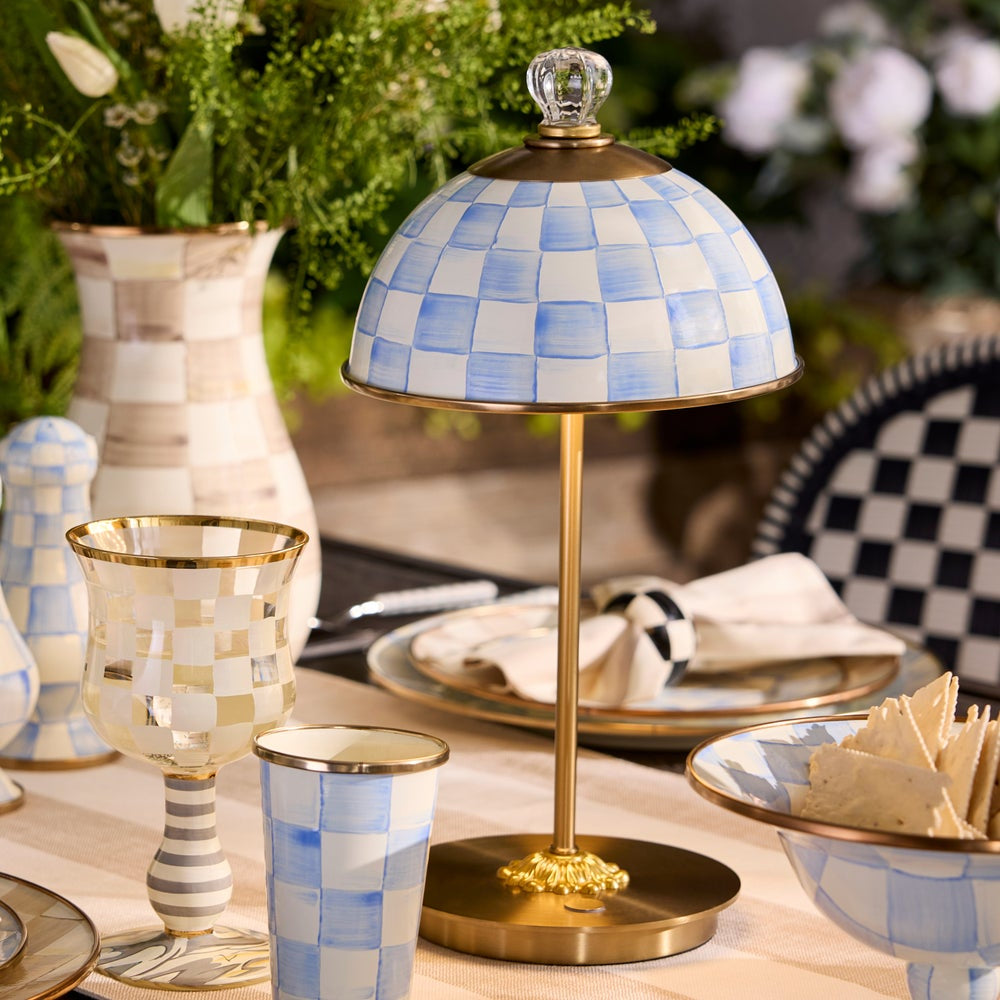 Decorative table lamp with checkered design on a table setting with glasses and plates.