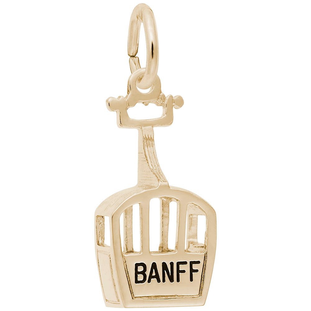 Gold gondola charm with 'BANFF' written on it on a white background