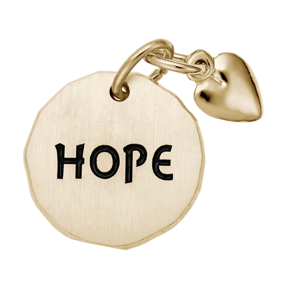 Gold disc charm with 'HOPE' engraving and a heart shaped bangle on a white background