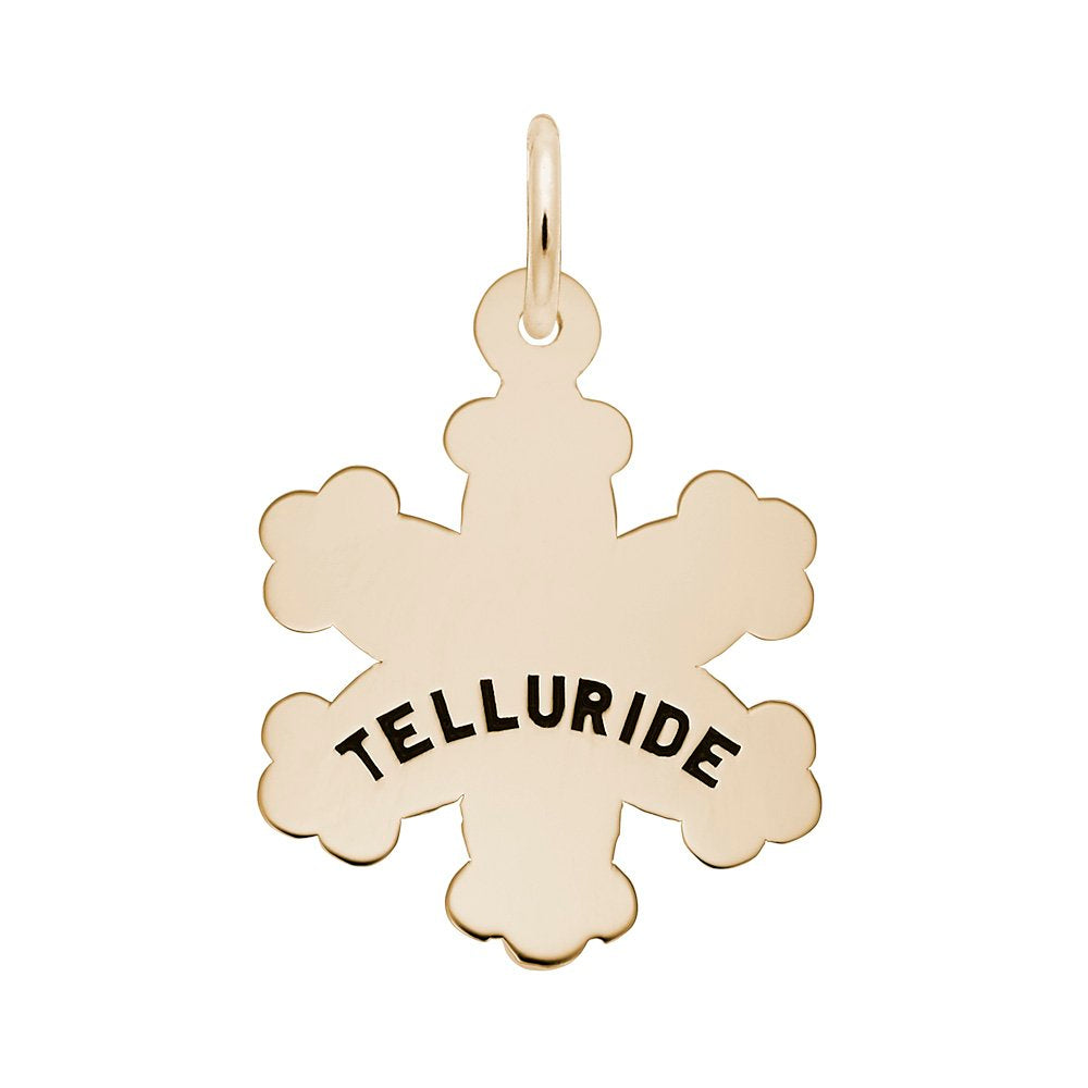 A gold snowflake charm engraved with the word 'TELLURIDE' in black capital letters, shown on a plain white background.