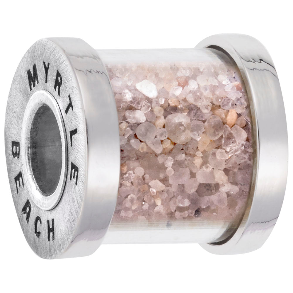 Bead capsule containing sand from Myrtle beach with silver ends with 'MYRTLE BEACH' engraved on it on a  white background