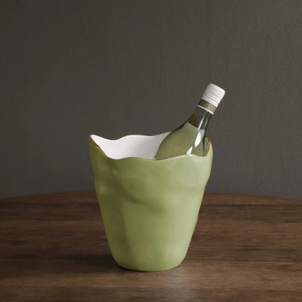 Green wine cooler with a bottle inside on a wooden surface