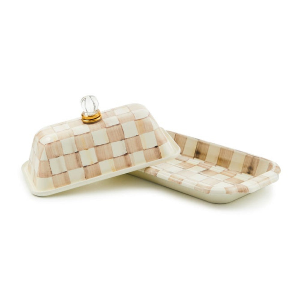 Butter dish with checkered pattern and glass lid on a white background