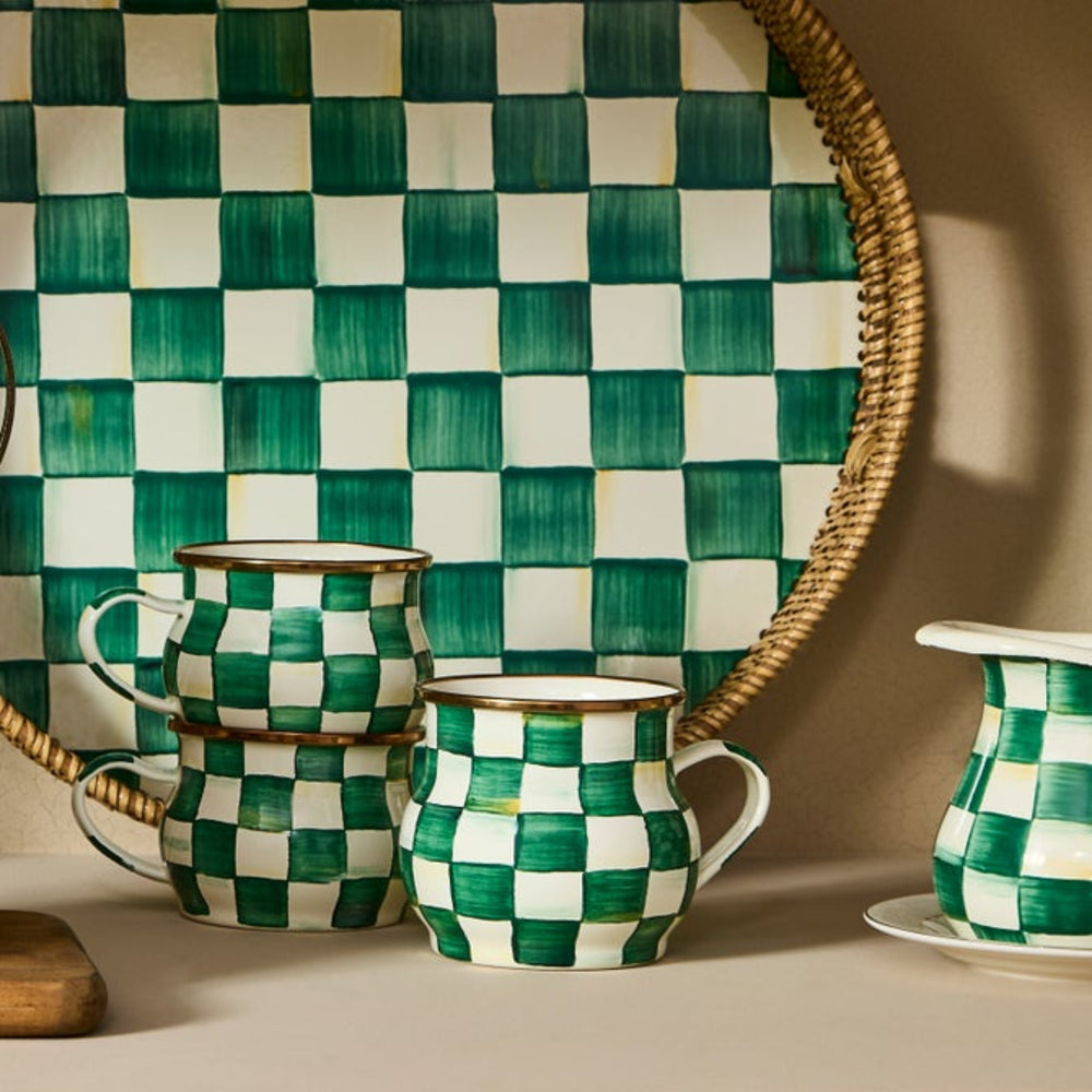 Green and white checkered mugs on a table with a checkered wall in the background
