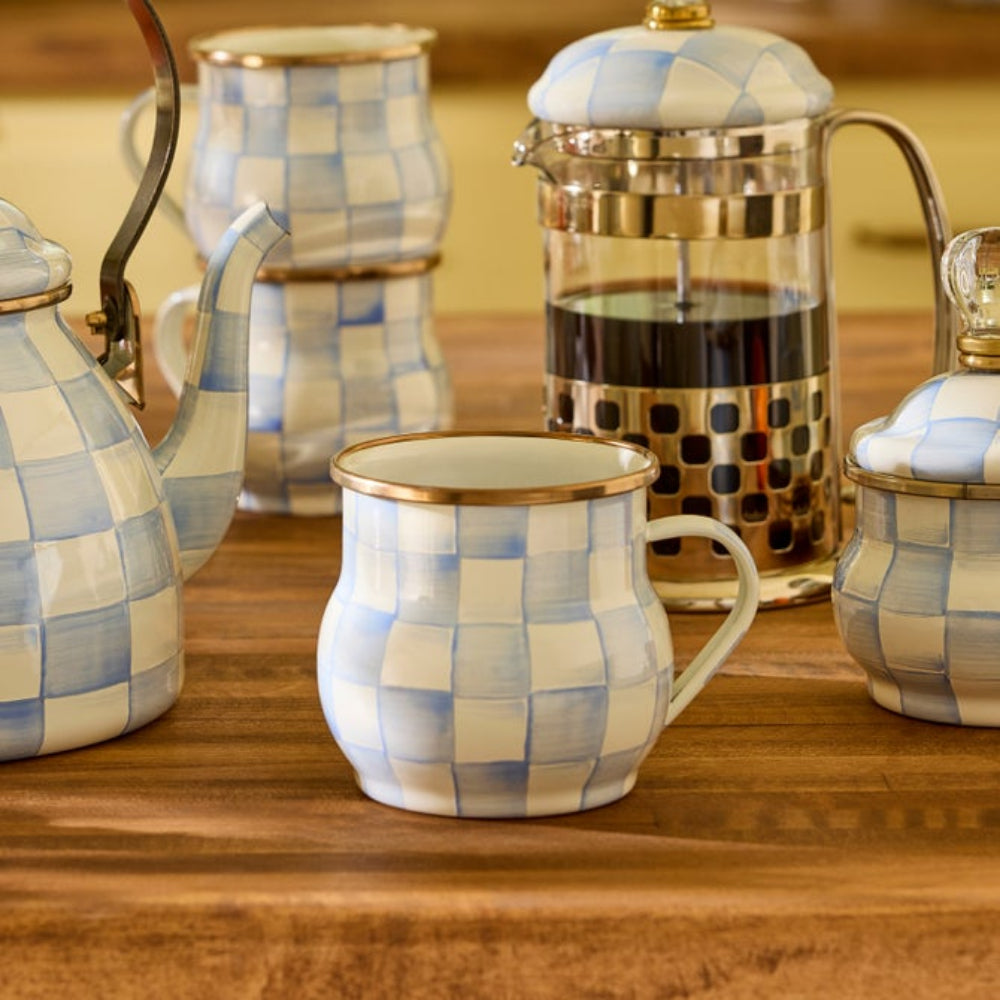 Sky Check Checkered ceramic mug with other sky check decor pieces such as canisters and tea kettles on a wooden surface