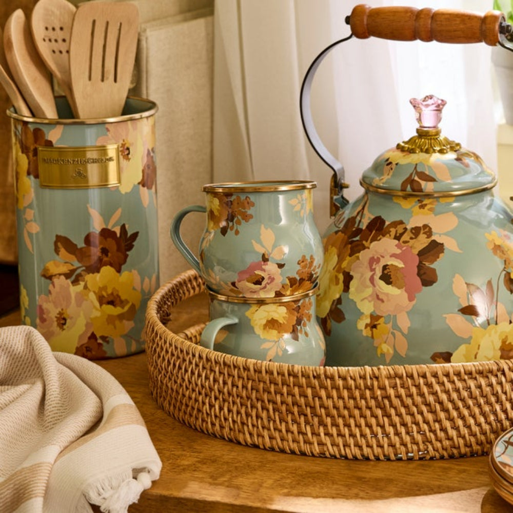 Blue floral-patterned teapot and mugs on a wooden surface with a woven basket.
