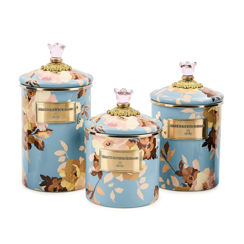 Set of three decorative jars with floral patterns and gold accents on a white background
