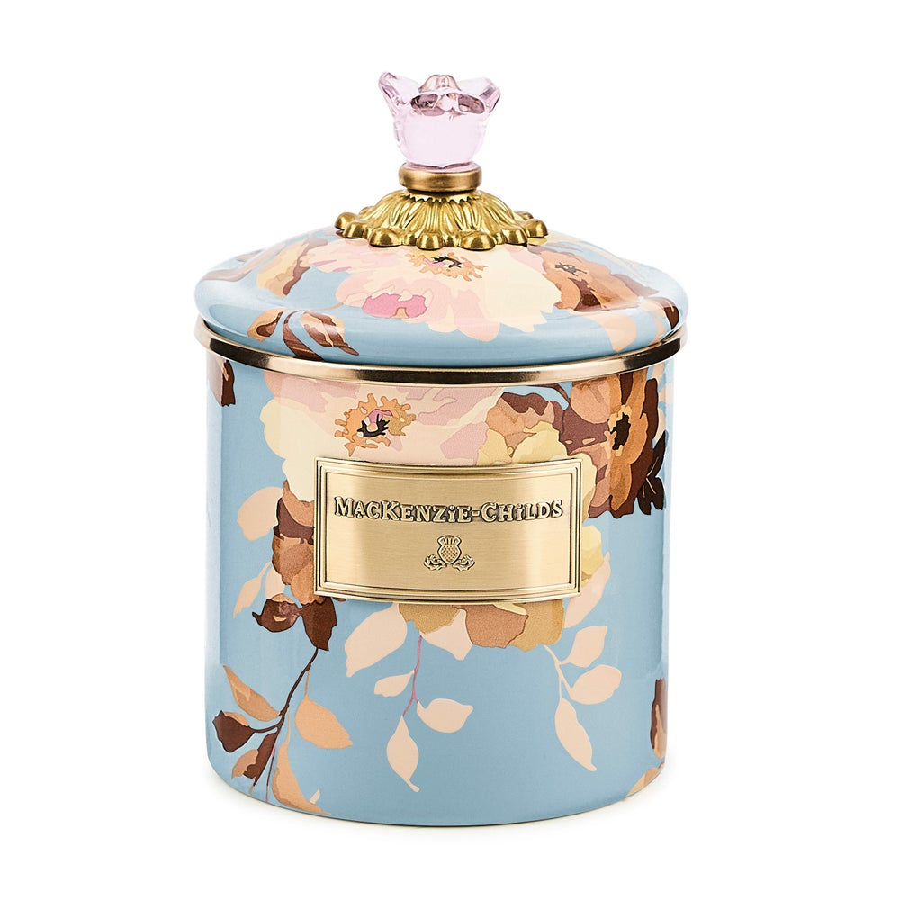 Decorative candle with floral design and gold accents on a white background