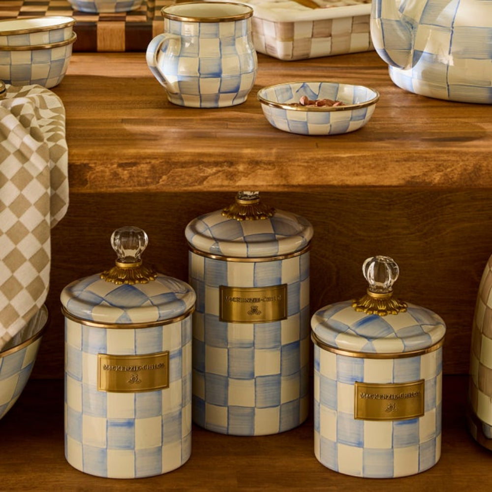 Set of ceramic Sky Check canisters with checkered pattern and gold accents on a wooden surface. Surrounded by other Sky Check decor items. 