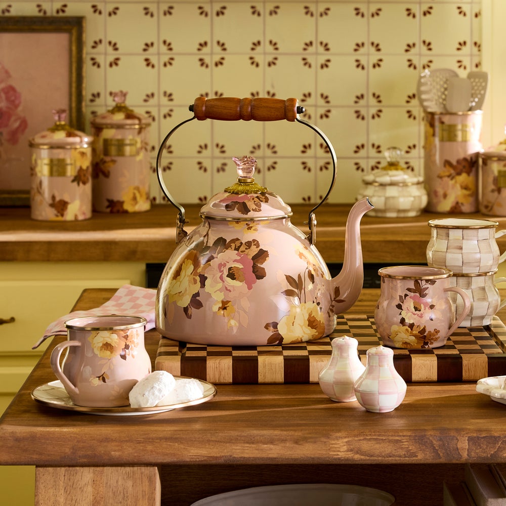 Pink Floral teapot and cups on a wooden table with decorative background