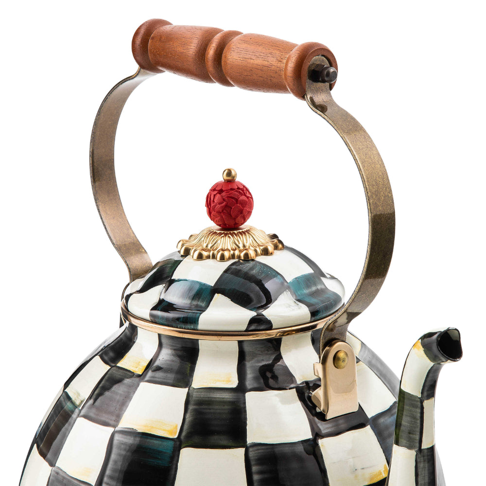 A close up photo of a decorative teapot with black and white checkered pattern with handle on a white background.