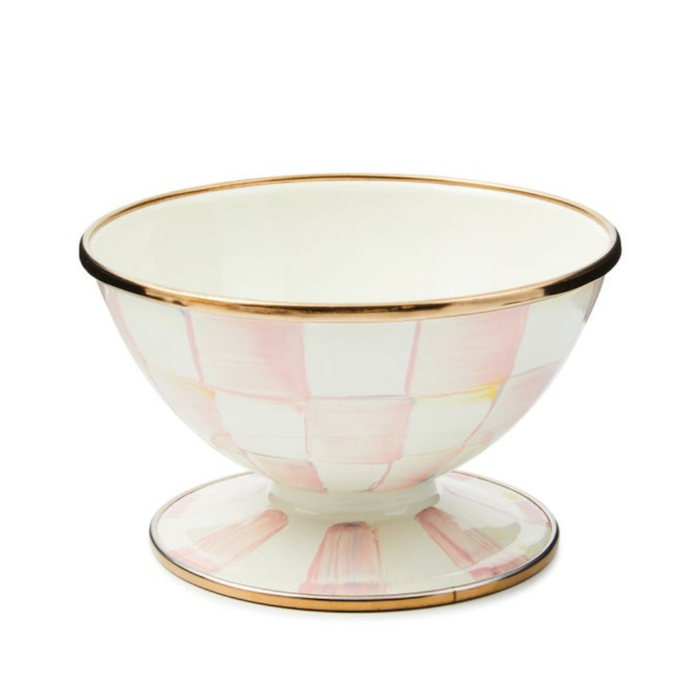 A footed ceramic bowl with a white and light pink checkerboard pattern and gold trim, set against a plain white background.