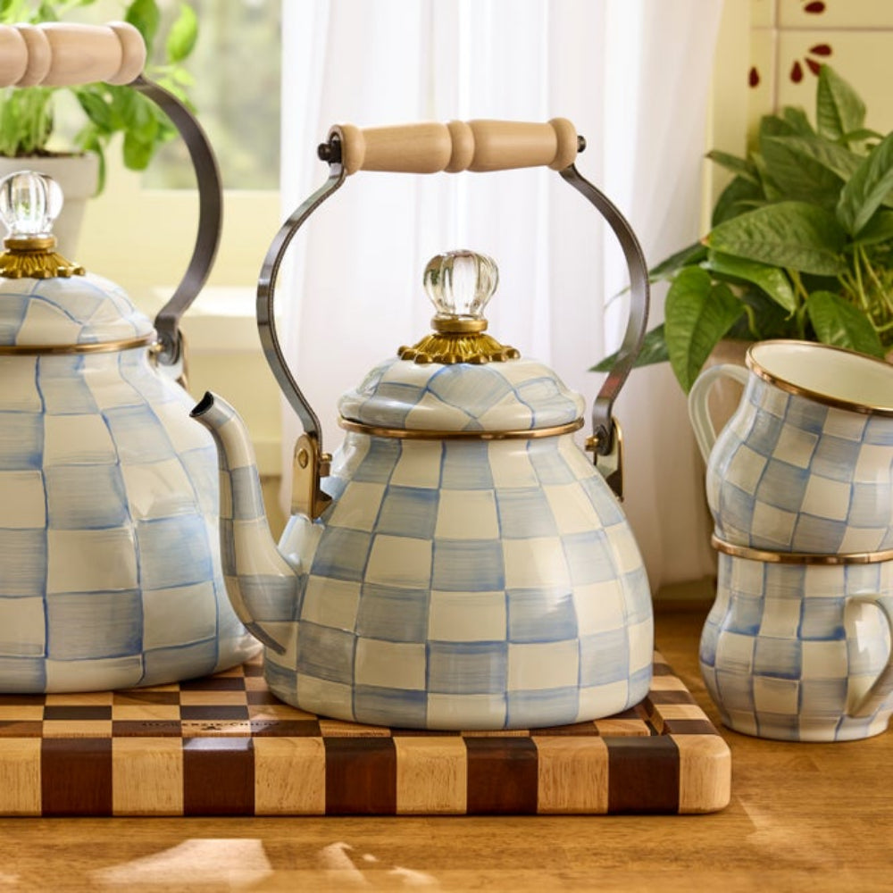 Decorative sky check tea kettles and mugs with checkered pattern on a wooden surface.