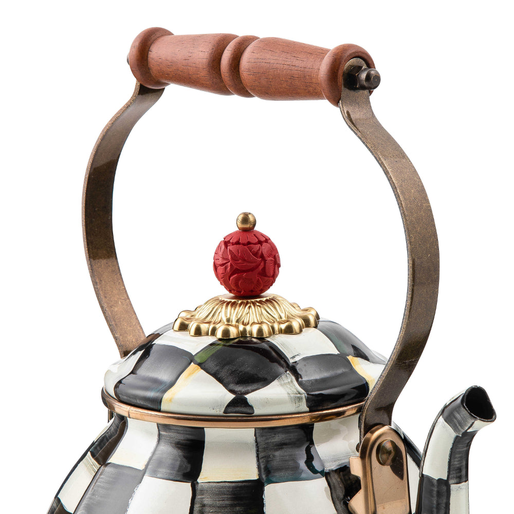 A close up photo of a decorative teapot with black and white checkered pattern with handle on a white background.