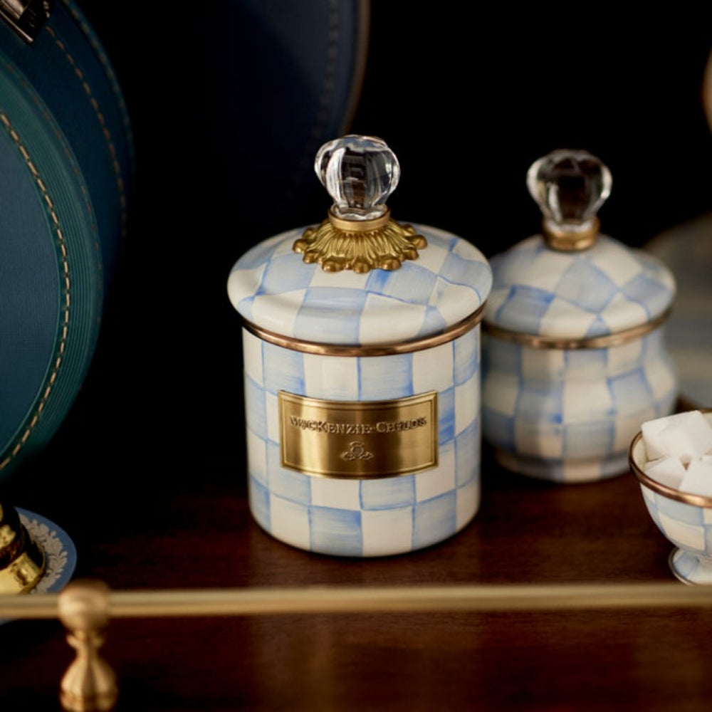 Decorative sky check canisters and jars with checkered pattern and gold accents on a wooden surface.