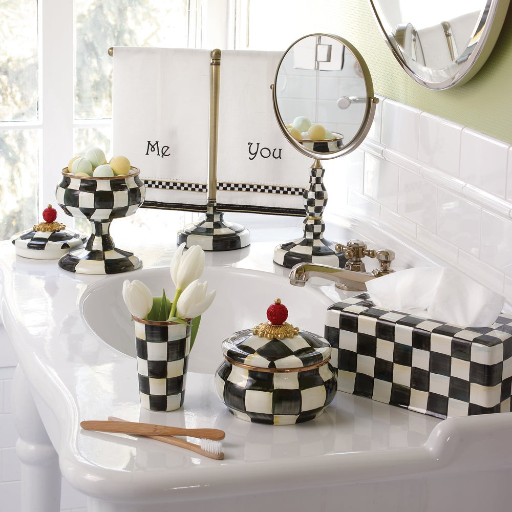 Bathroom vanity with checkered decor, including a mirror, soap dish, and small container.