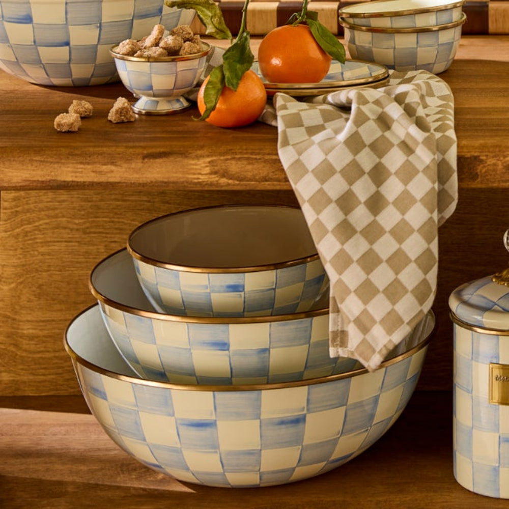 Set of sky check checkered ceramic bowls on a wooden surface with a towel, a fruit display, and other sky check decor items from MacKenzie. 