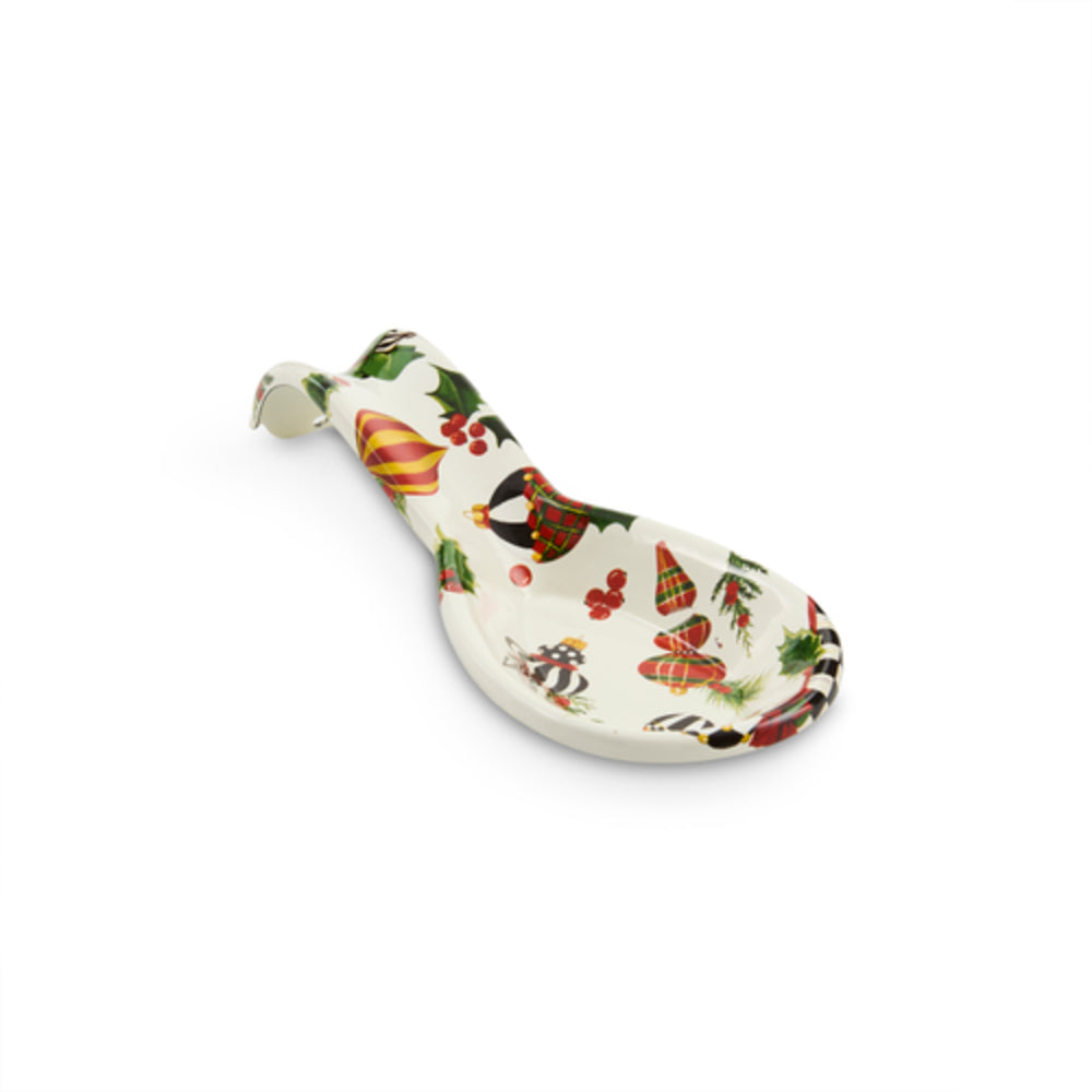 A small ceramic spoon with a white base decorated with colorful autumn leaves and floral patterns, shown on a plain white background.