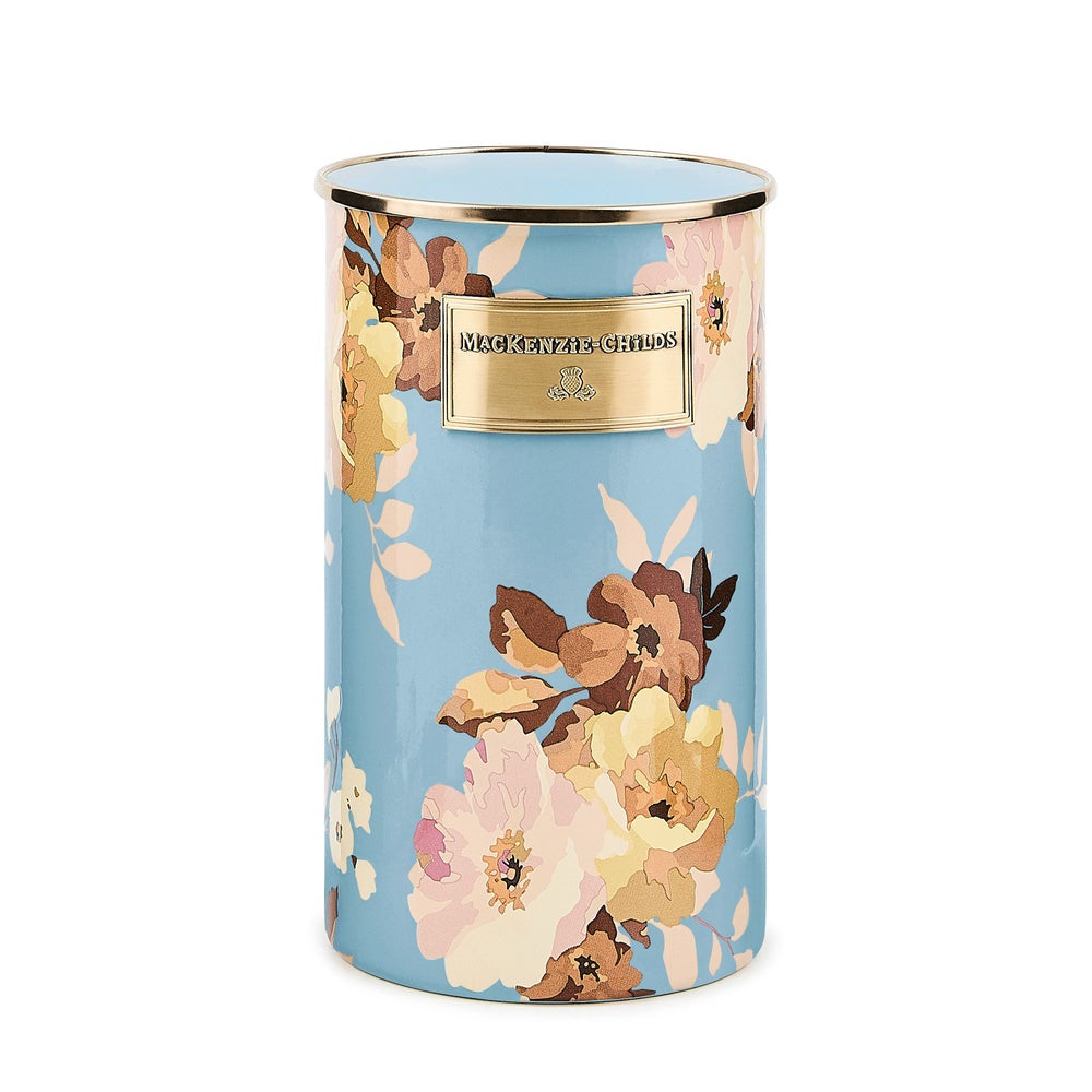 Floral-patterned candle with gold lid on a white background