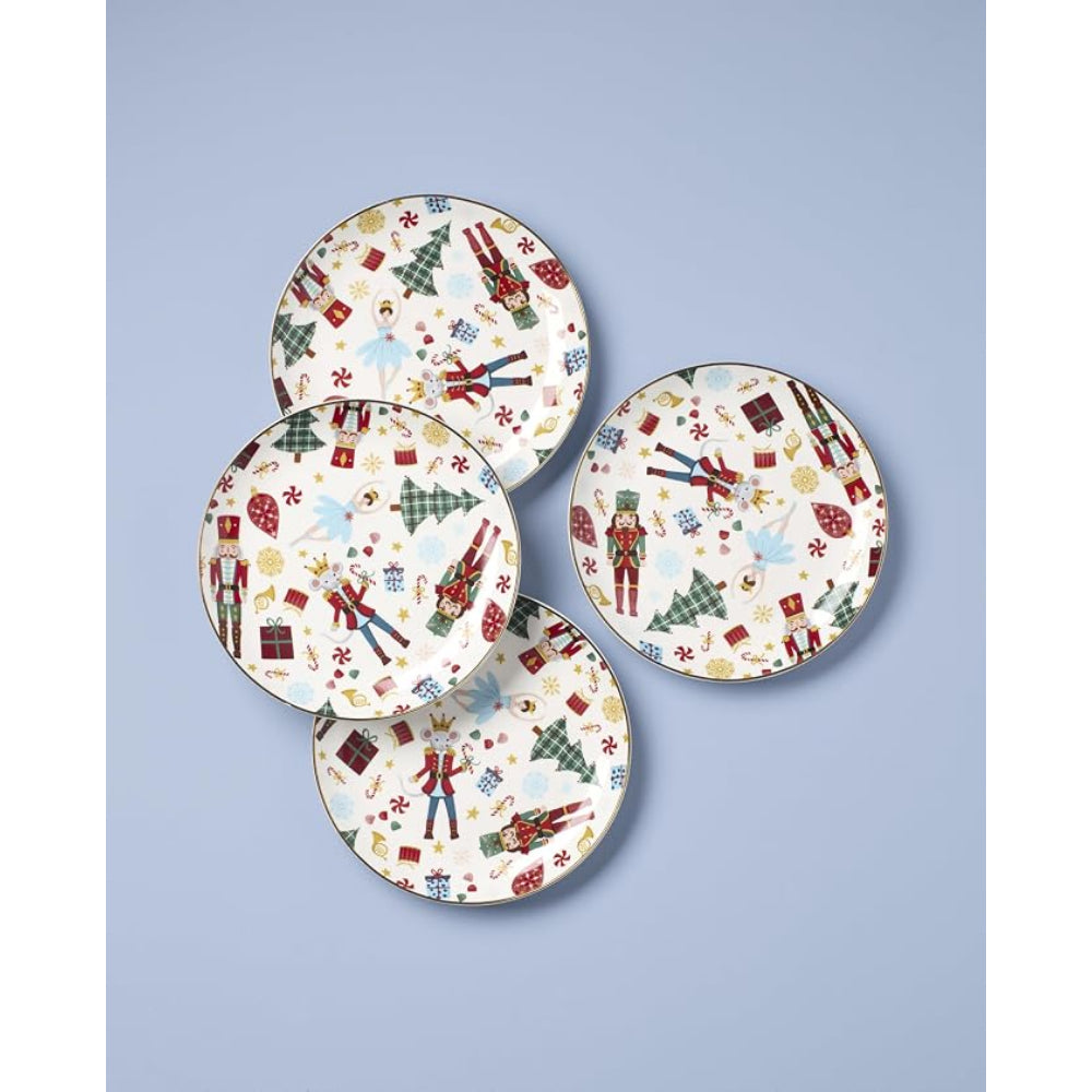Four round holiday-themed plates with a white background and a colorful Christmas pattern featuring nutcrackers, soldiers, Christmas trees, and gifts, arranged on a light blue background.