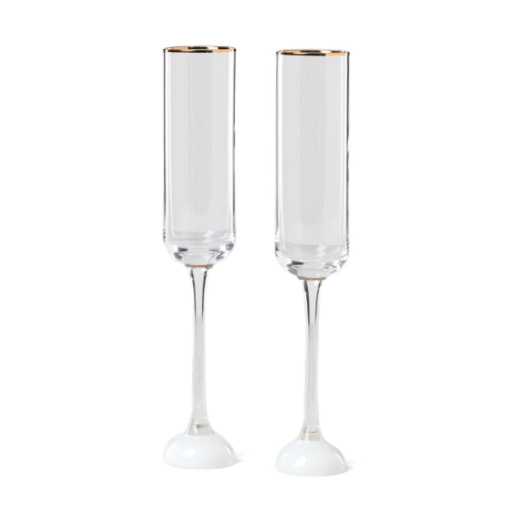 Two white champagne flutes with gold rims on a white background