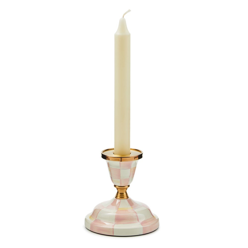 Candle holder with a checkered design holding a candle on a white background