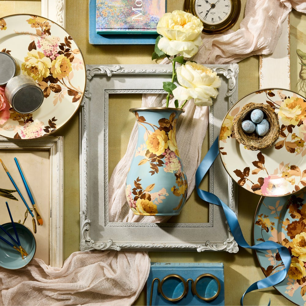 Decorative still life with floral patterns on plates, a vase, and a clock.