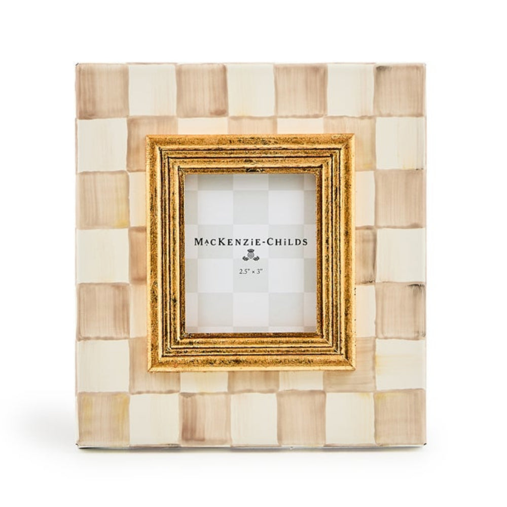 A square MacKenzie-Childs picture frame featuring a woven checkered pattern in cream and light tan, with a gold inner frame and a white insert card displaying the brand name.