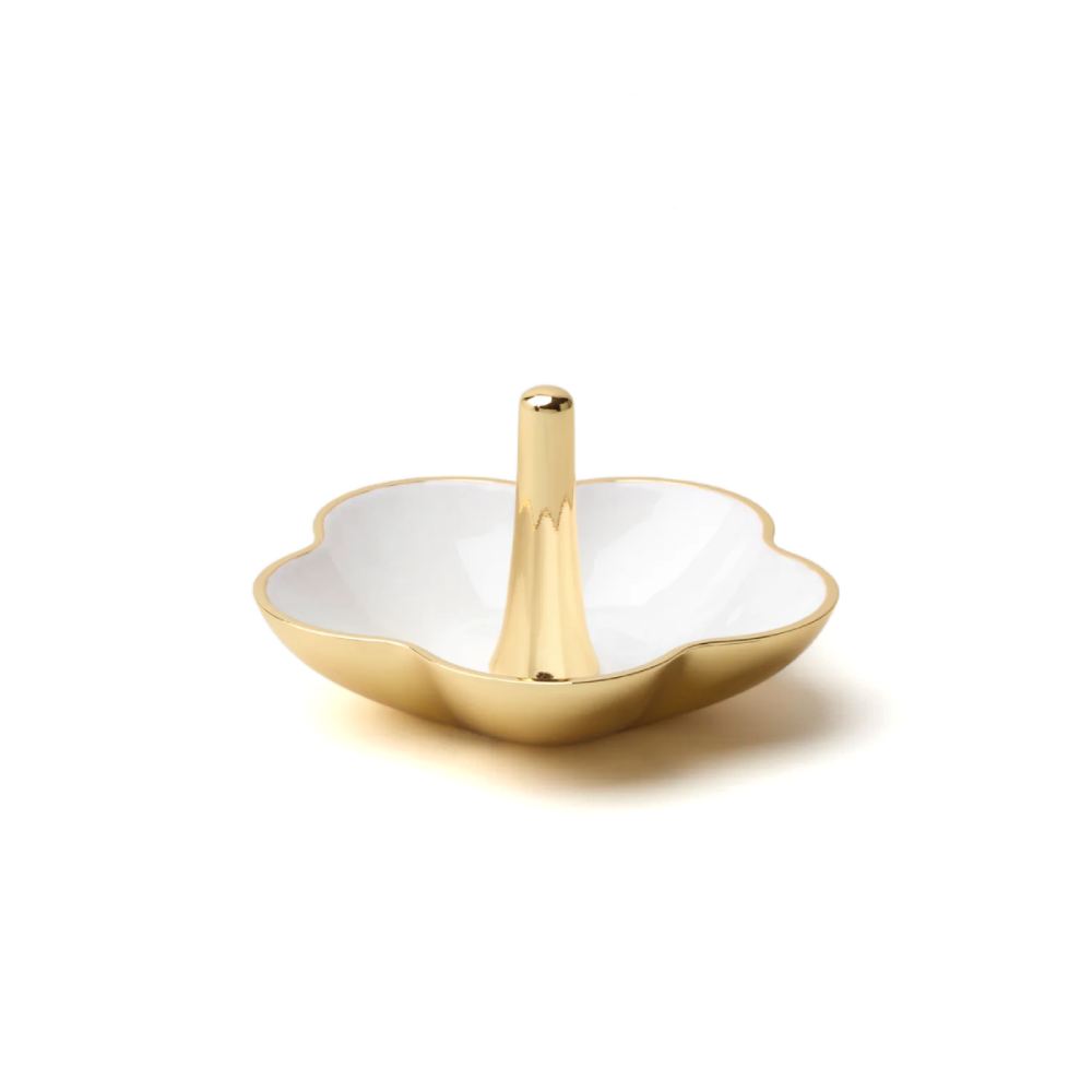 Decorative gold ring dish with white interior and gold exterior on a white background.