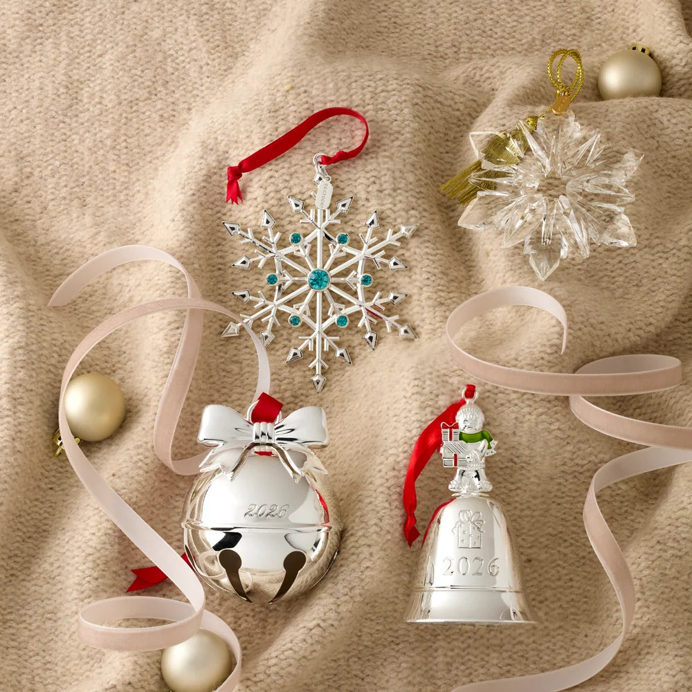 Collection of Christmas ornaments including a snowflake, bell, and other decorative items on a beige fabric background.