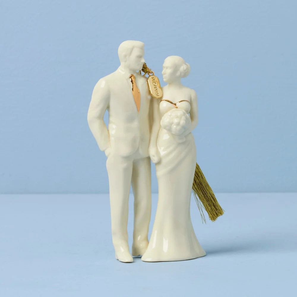 White ceramic figurine of a couple with gold accents on a light blue background