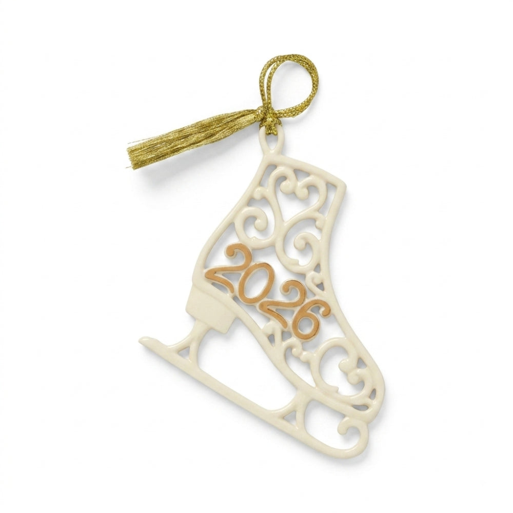 A decorative ice skate-shaped ornament in warm ivory with an integrated gold tassel and gold '2026' lettering, shown on a clean white background.
