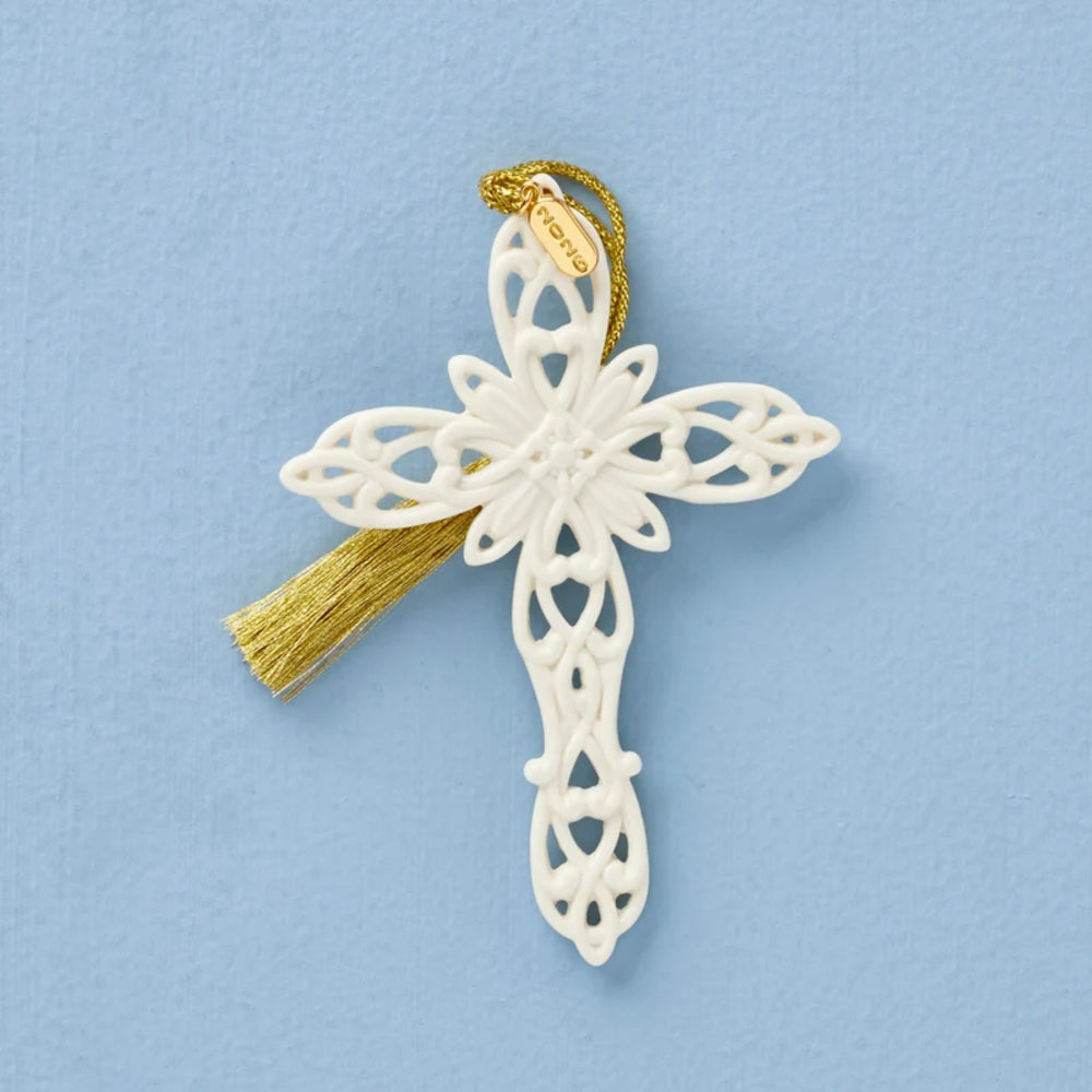 Decorative white cross with gold tassel on a light blue background