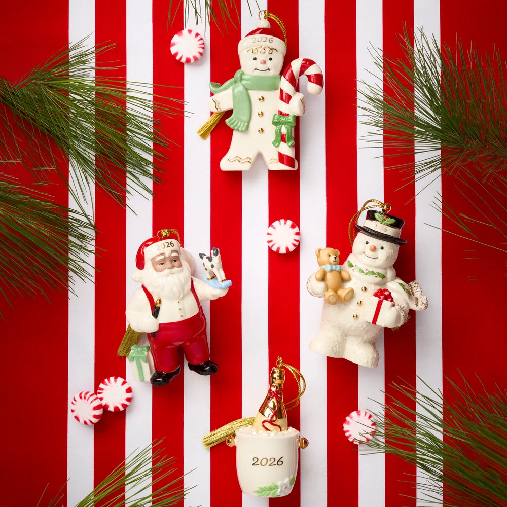 Three Christmas ornaments arranged on a red and white striped background with pine branches and candy canes: a Santa Claus ornament, a snowman ornament, and a mug ornament with '2026' printed on it.
