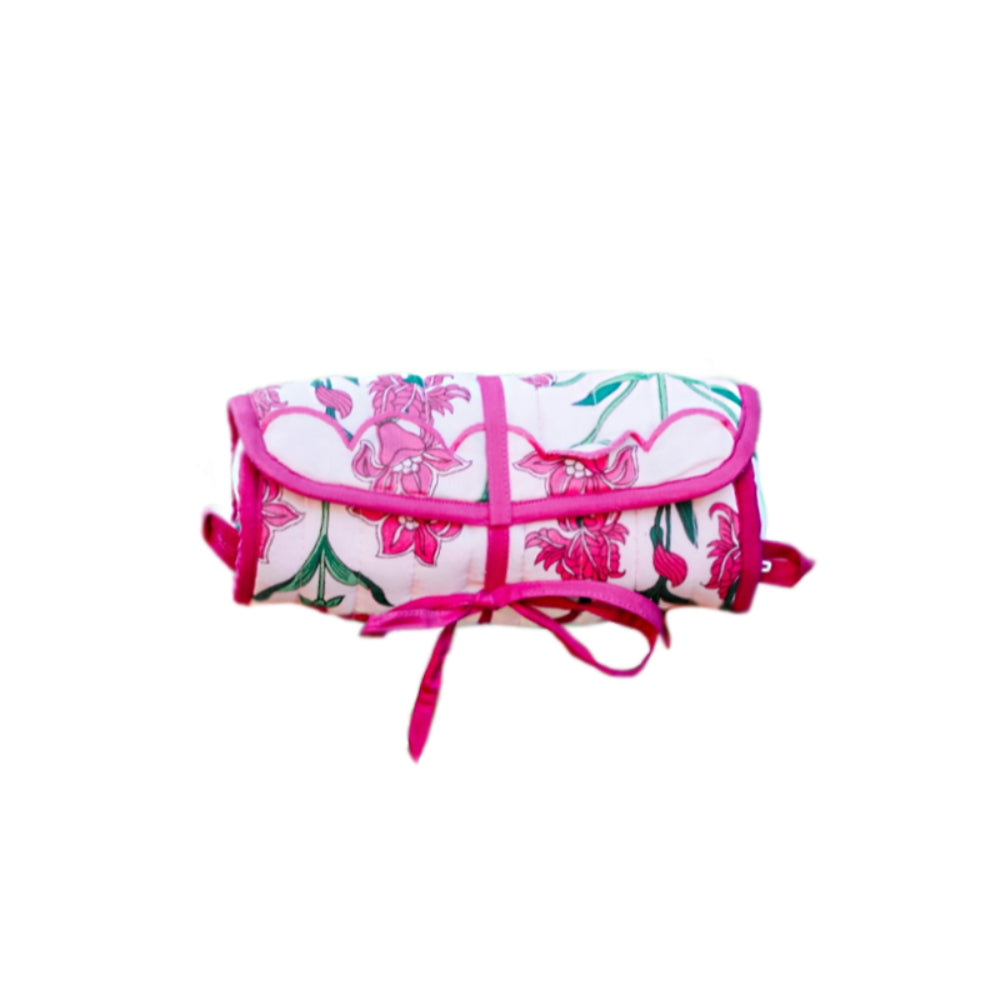 A pink and white patterned clutch jewelry roll on a white background
