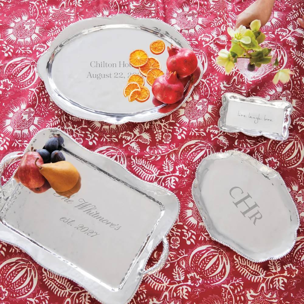 Decorative silver trays with fruit on a red patterned tablecloth