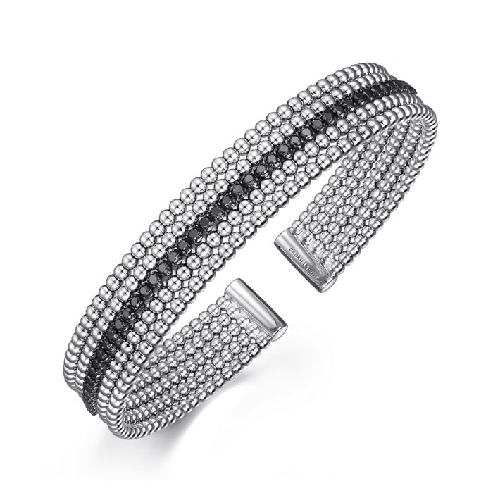 A silver-toned multi-row cuff bracelet featuring rows of clear and dark round stones, displayed on a clean white background.