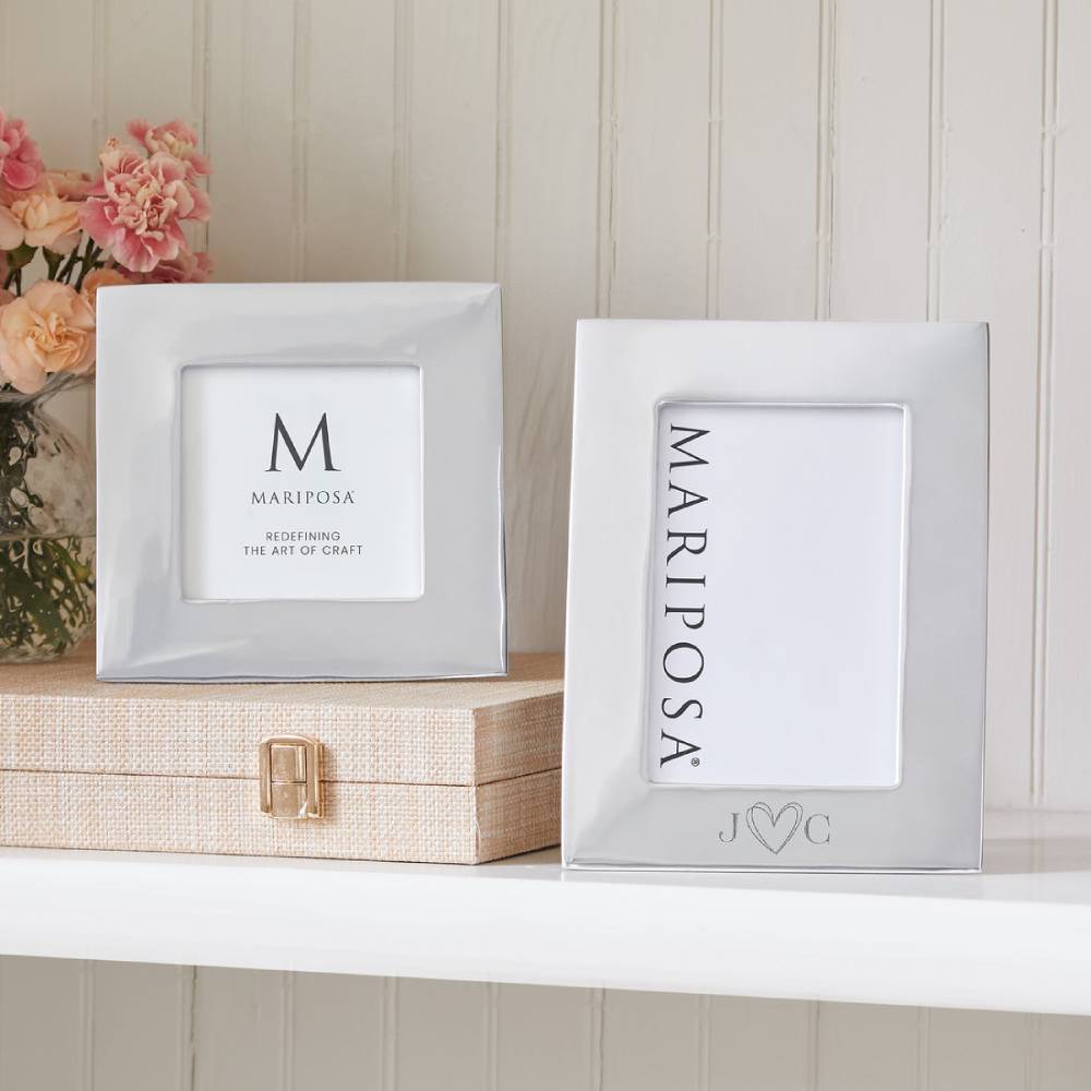 a set of polished silver finish square and rectangular picture frames branded "MARIPOSA" on a white shelf with a white wood background